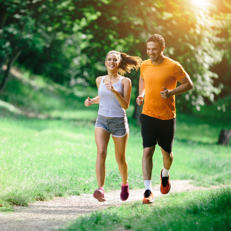 Healthy couple jogging in nature in good spirit